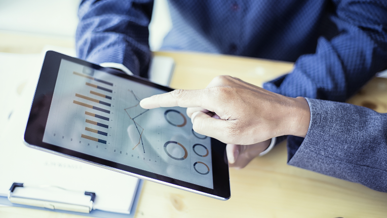 Business people analyzing investment charts on tablet in meeting room.