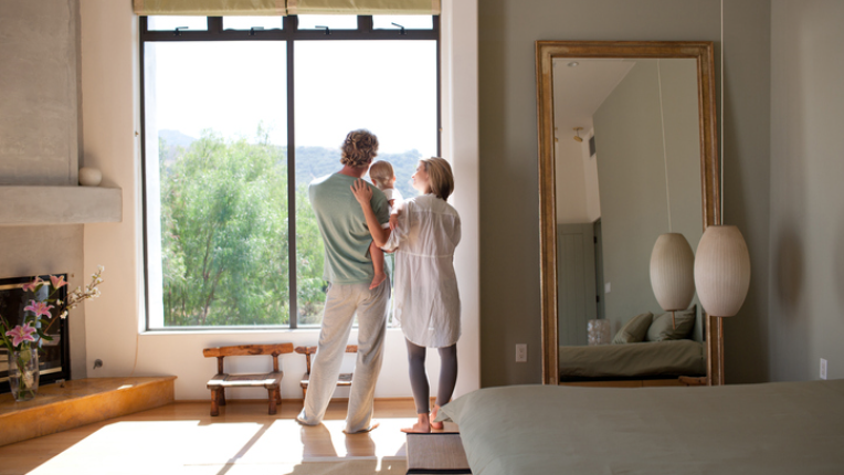 Couple and baby son looking out window.
