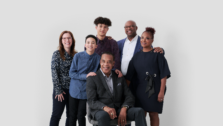 Multi-cultural family smiling and posing for photo.