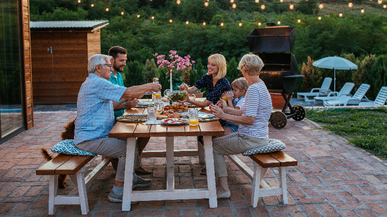 Multigenerational family gathering at dinner party in the backyard.