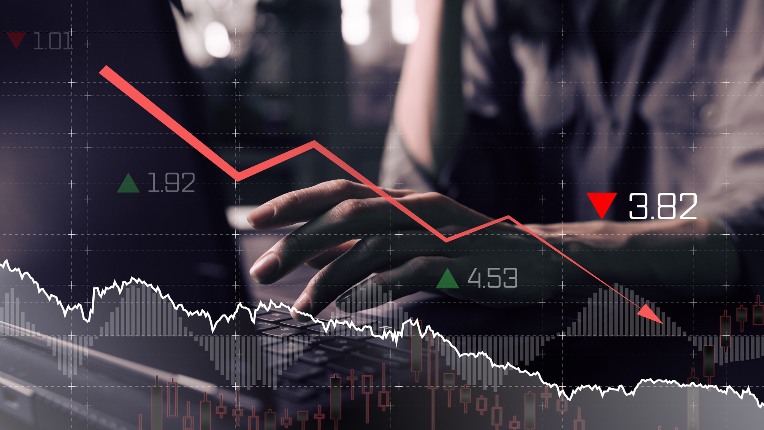 Financial graph and person typing on a laptop.