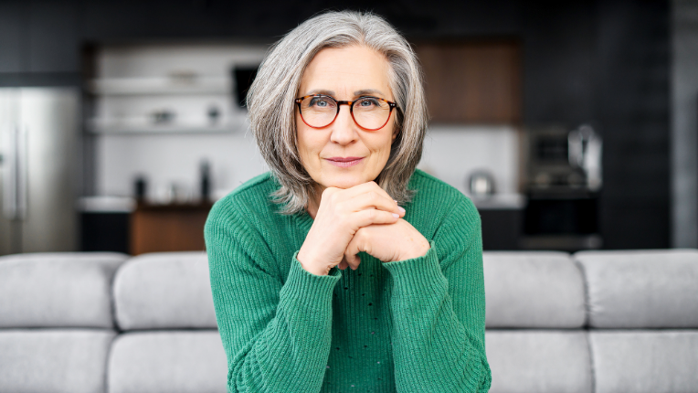 A woman sitting on a couch and staring ahead.
