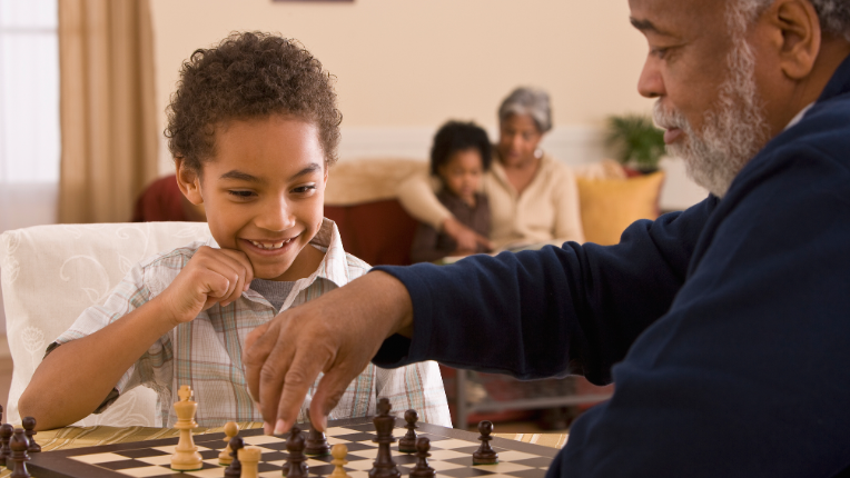 Grandfather and grandchild playing chess.
