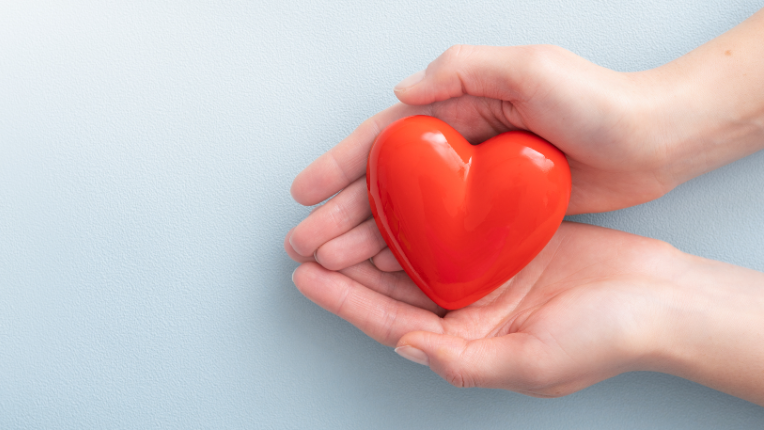 Two hands holding a heart shape.
